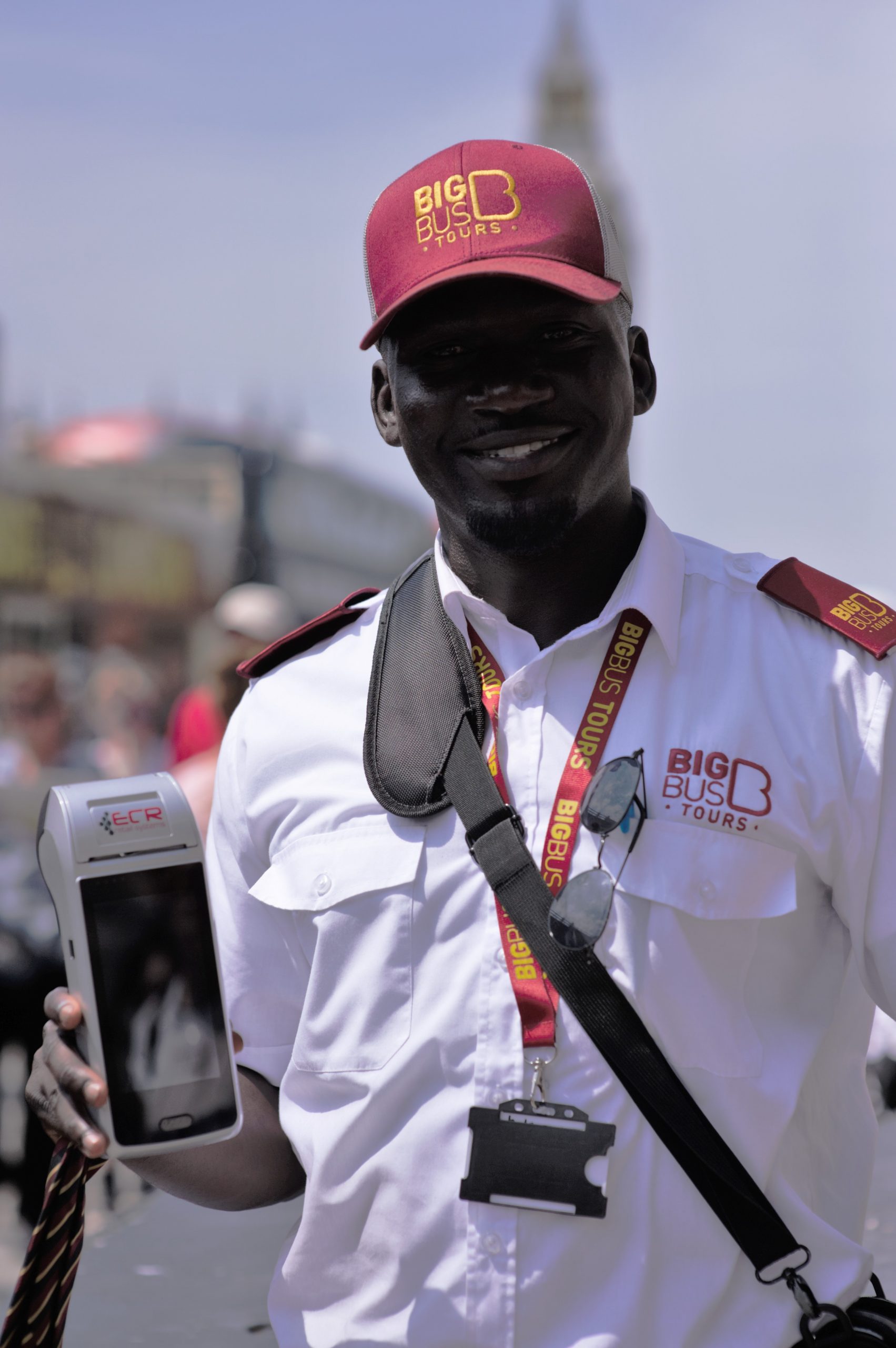 big bus tours worker holding ecr device